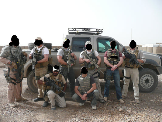 Military members in front of a tactical vehicle
