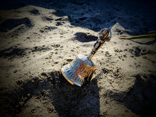 buddhist bell of enlightenment on sandy beach near ocean